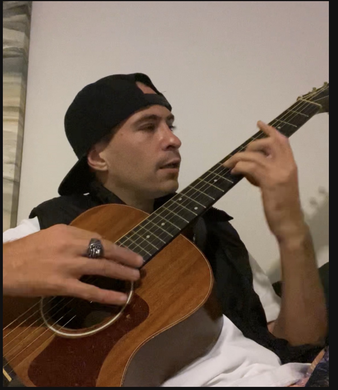 Max Scott playing acoustic guitar